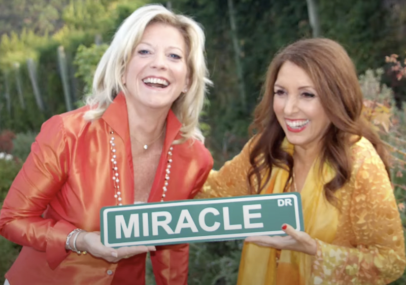 Marci Shimoff & Dr. Sue Morter holding the Miracle sign